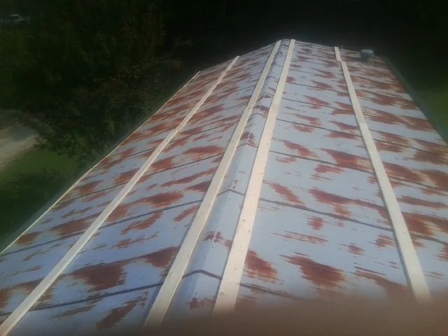 Rusted metal roof panels with new wood purlins before replacement — Storm Damage Roof Repair in Osceola by Roofing Brothers